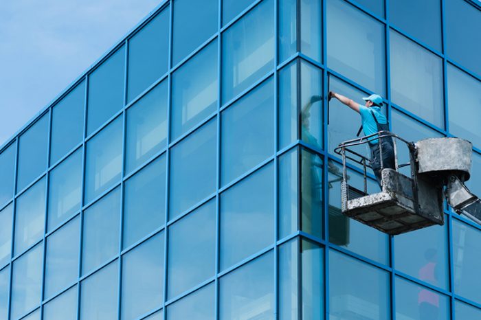 Reinigung einer Fassade aus Kran in Leer